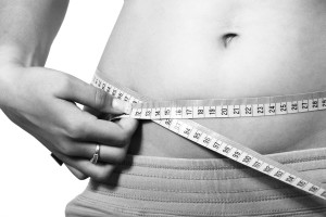 A woman measuring her waist